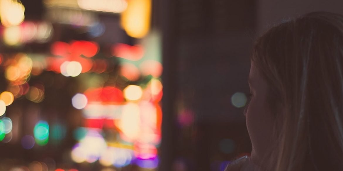 This shows a young woman looking out of a window