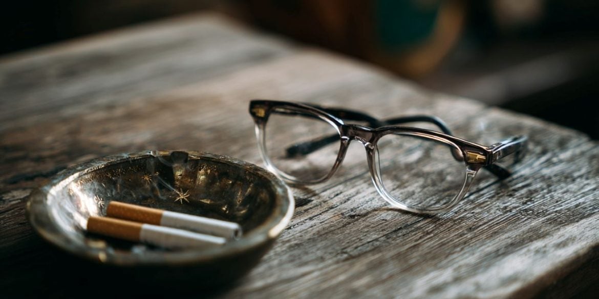 This shows a pair of eye glasses next to an ashtray, symbolizing the connection between smoking and AMD.