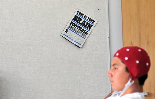 The image shows a person undergoing a concussion evaluation with eeg.
